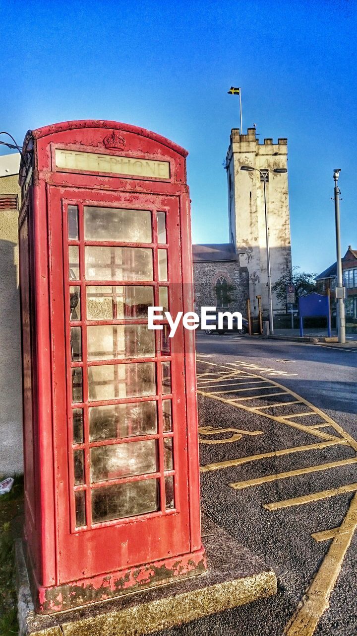 Public phone booth against clear blue sky