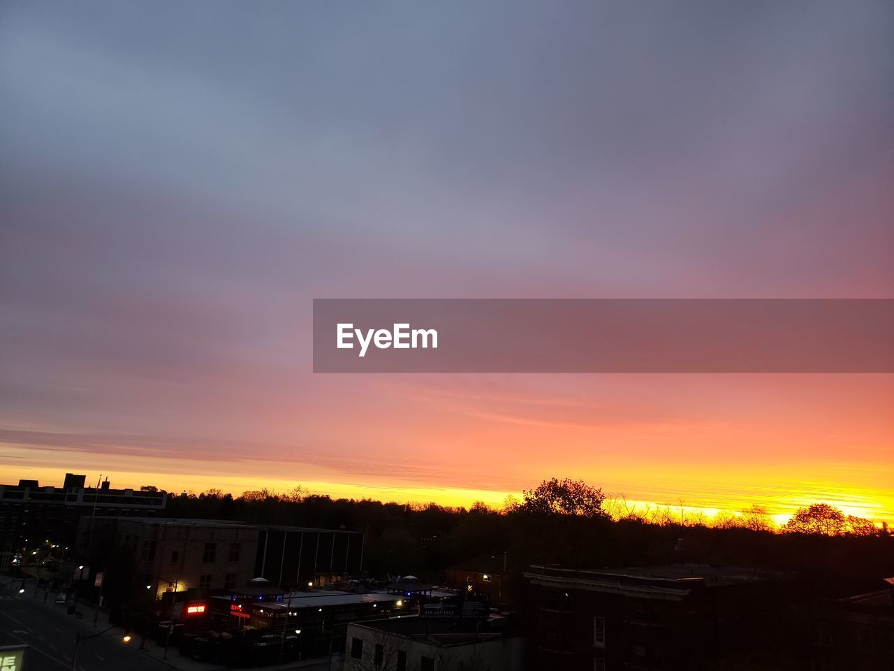 HIGH ANGLE VIEW OF ILLUMINATED BUILDINGS AGAINST SKY DURING SUNSET