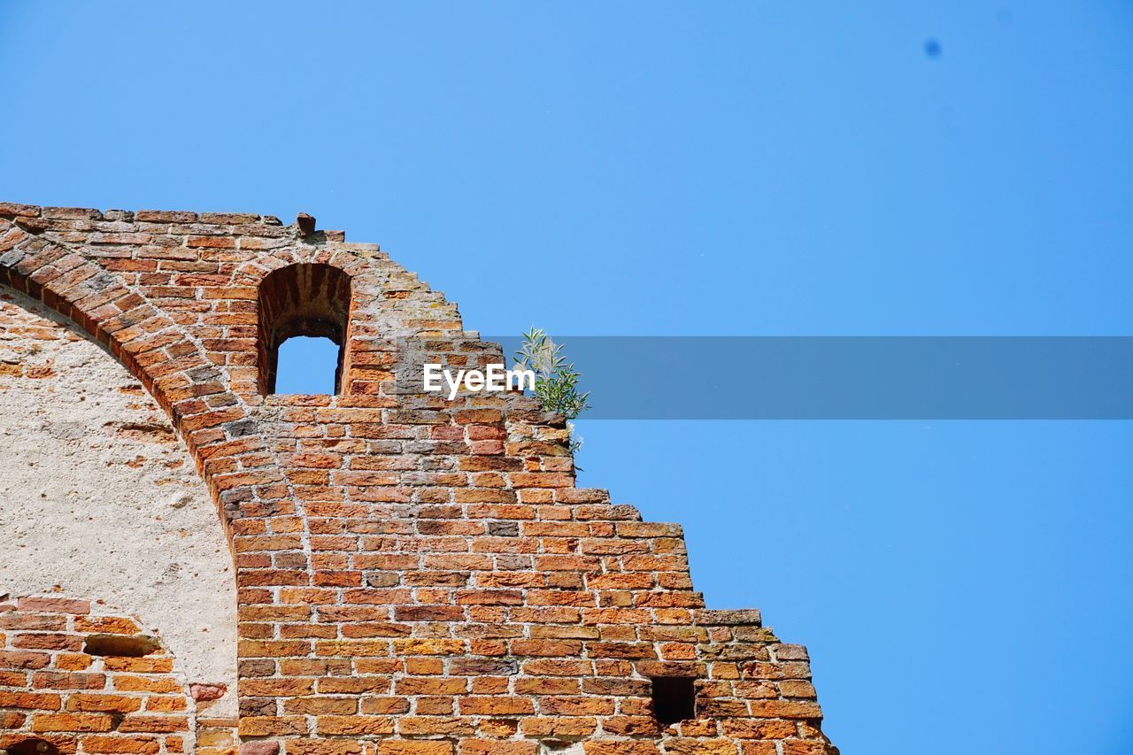 Low angle view of castle against clear blue sky