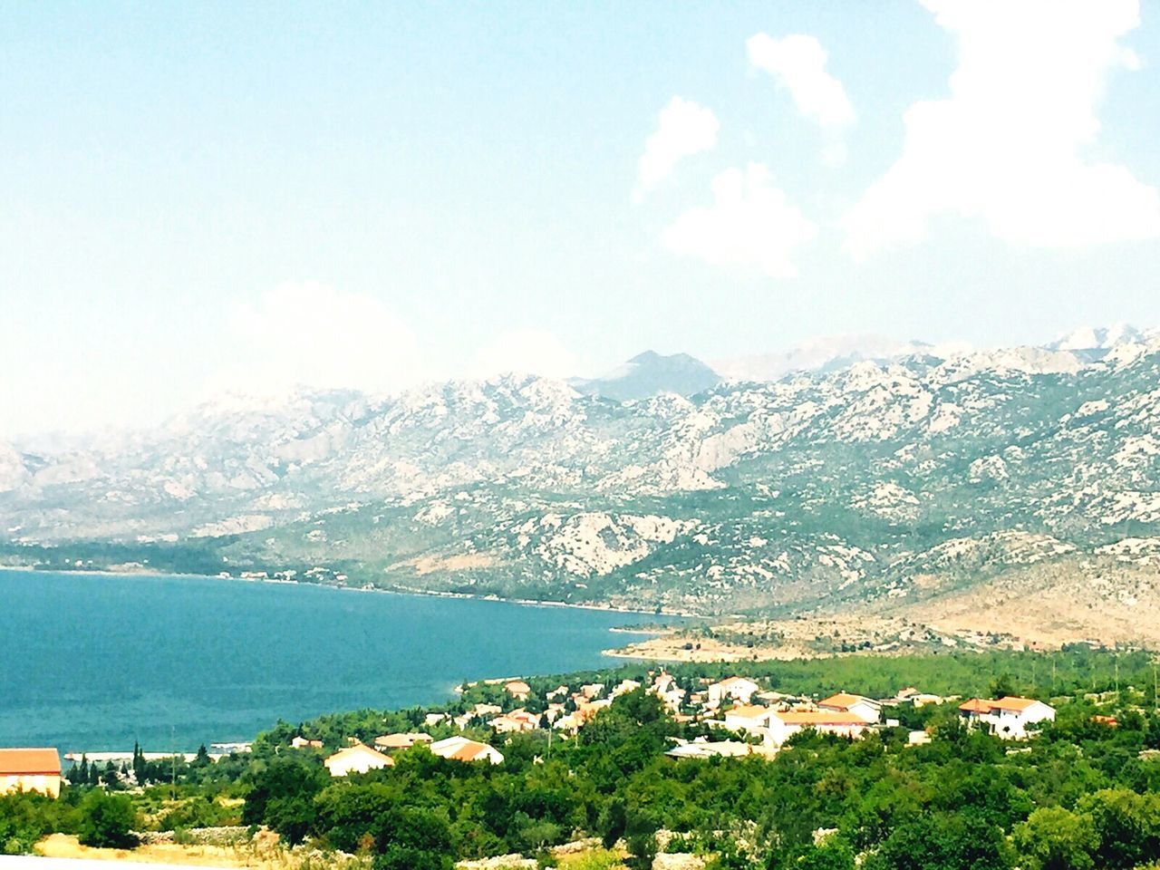 SCENIC VIEW OF RESIDENTIAL DISTRICT BY MOUNTAINS AGAINST SKY