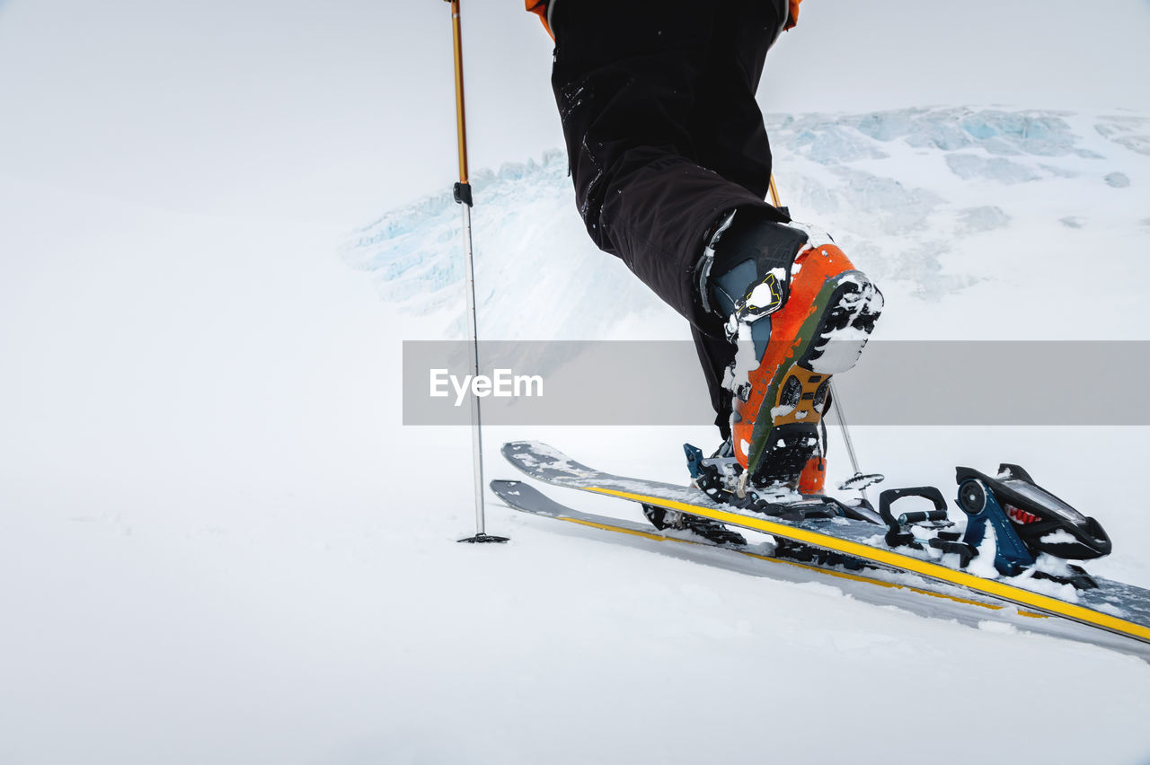 Close-up of freeride ski boots on snow. skitour concept. used worn boots on a male skier against the