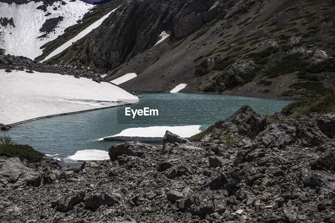 water, mountain, scenics - nature, beauty in nature, environment, nature, glacial landform, moraine, snow, cold temperature, no people, day, tranquility, lake, landscape, land, non-urban scene, tranquil scene, mountain range, winter, rock, outdoors, glacier, travel destinations, travel, glacial lake, ice, wilderness, remote