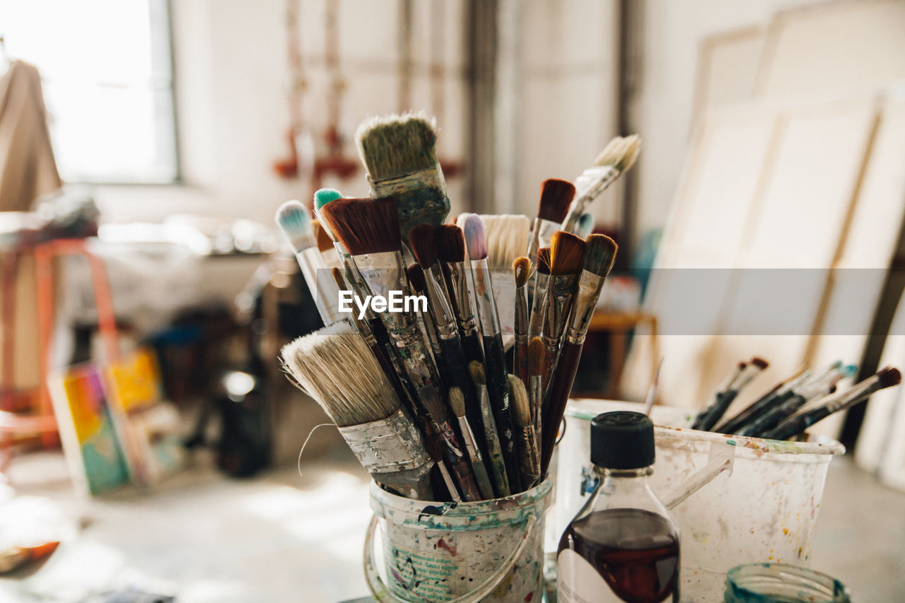 Close-up of paintbrushes in jar on table