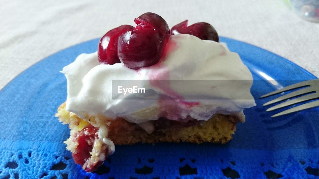 Close-up of cake slice with cherries in plate