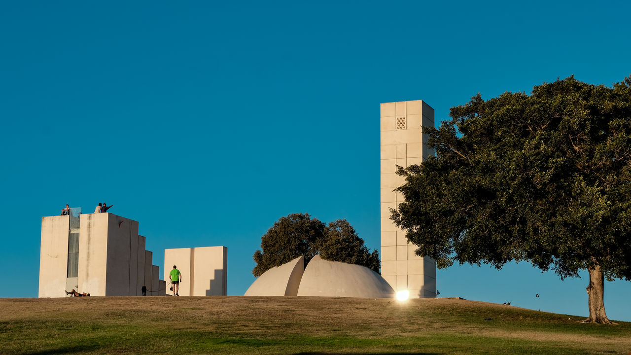 PARK BY BUILDING AGAINST CLEAR BLUE SKY