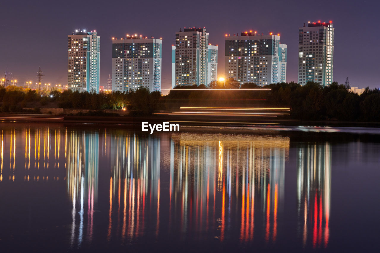 Reflection of illuminated buildings in lake at night