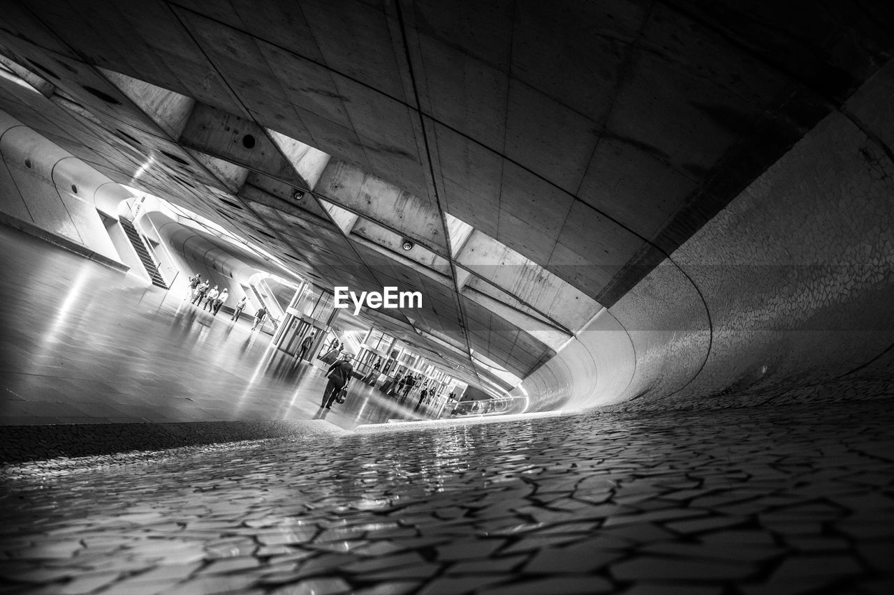 MAN IN ILLUMINATED UNDERGROUND WALKWAY