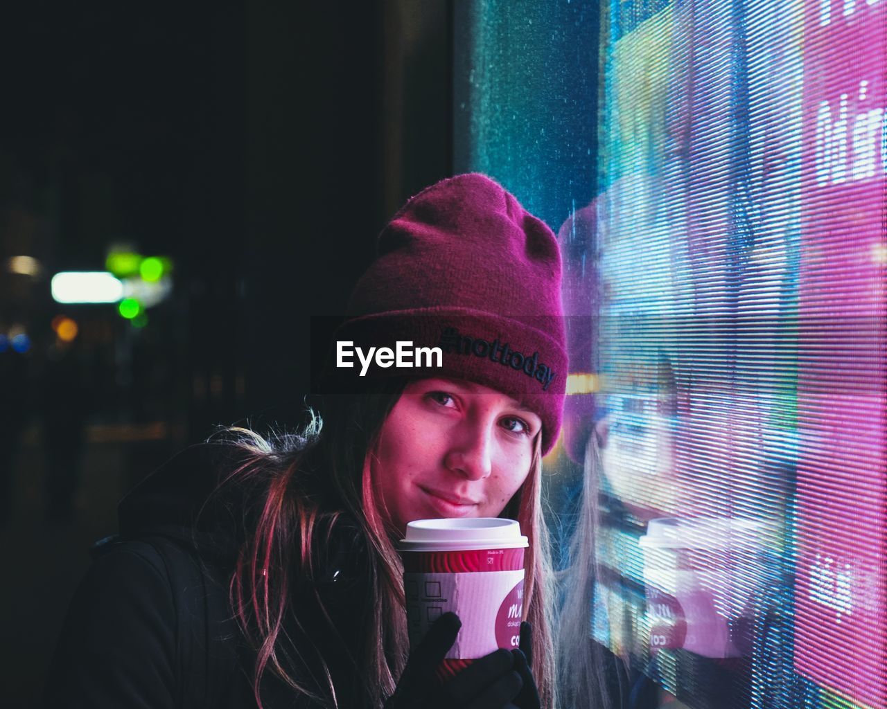 PORTRAIT OF A YOUNG WOMAN IN DRINKING GLASS AT NIGHT