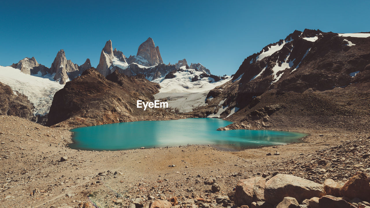 Scenic view of lake and mountains against clear sky