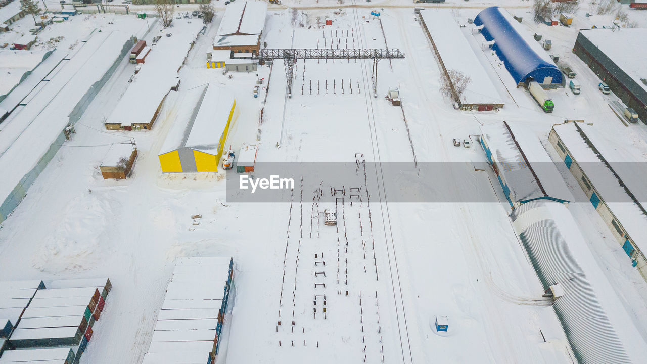 Metal structures on the background of a construction site in snow, manufactured workshop, warehouse