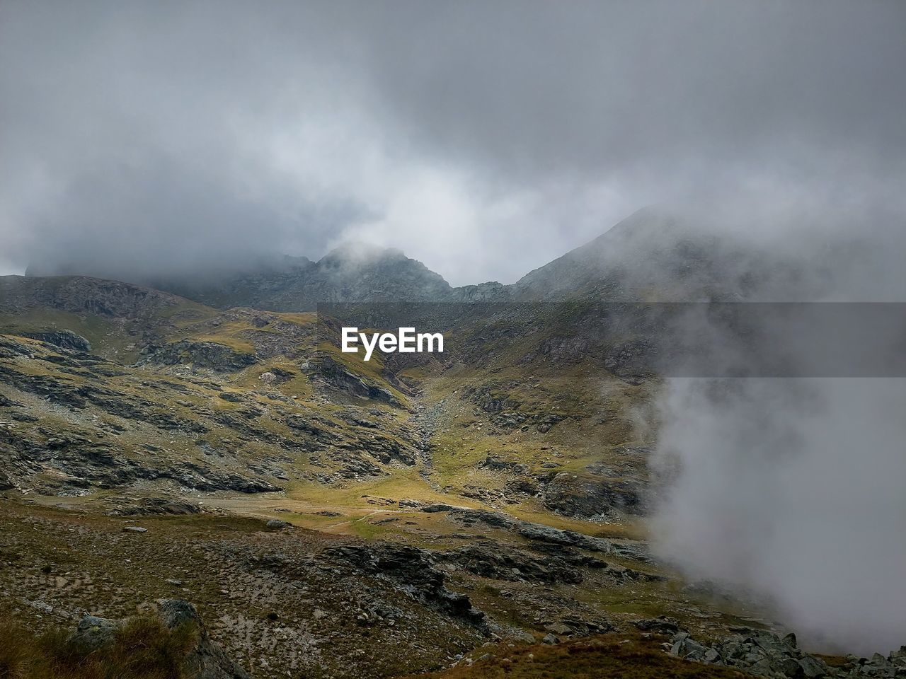 SCENIC VIEW OF MOUNTAINS AGAINST CLOUDY SKY
