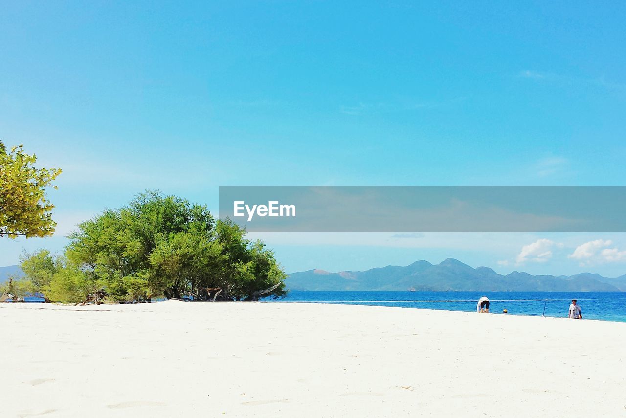 Scenic view of beach against blue sky