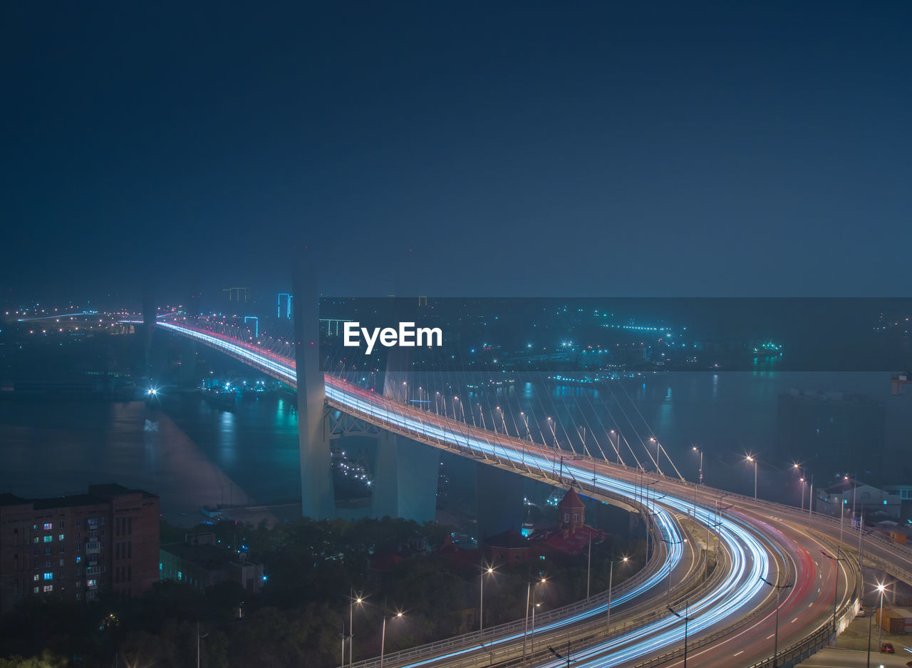 High angle view of illuminated bridge over river in city at night