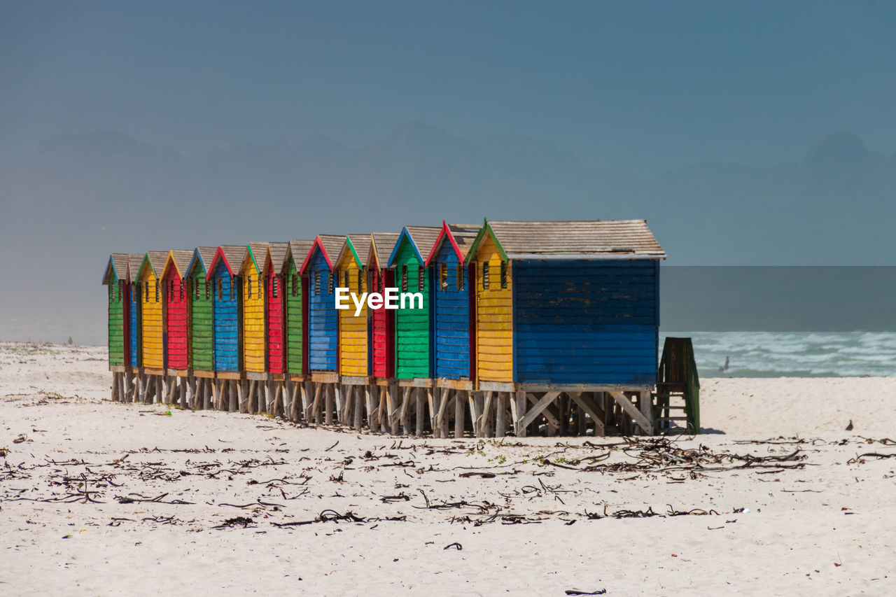 Multi colored beach houses in muizenberg near cape town, south africa against blue sky