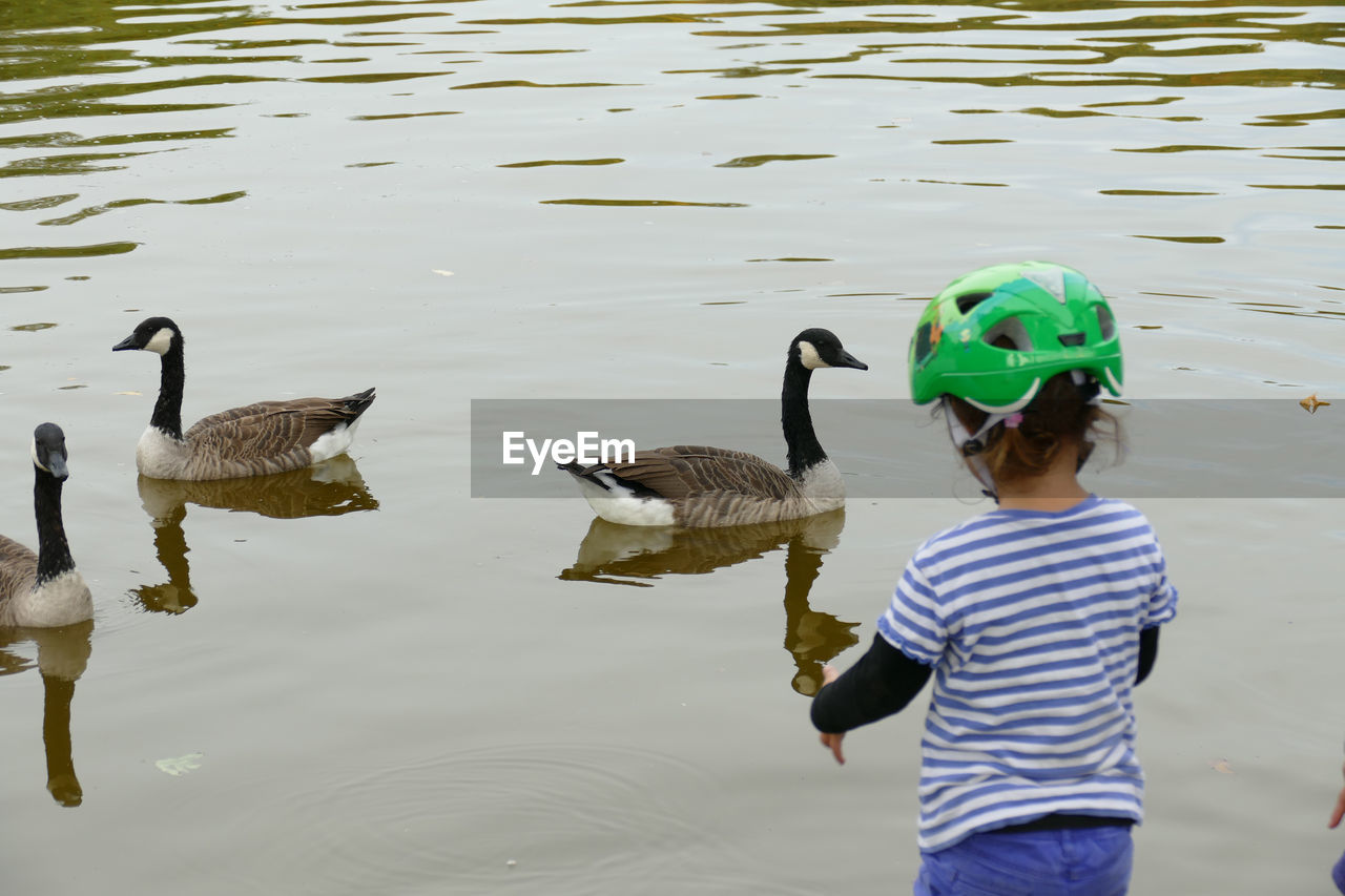 FULL LENGTH REAR VIEW OF BOY STANDING IN LAKE