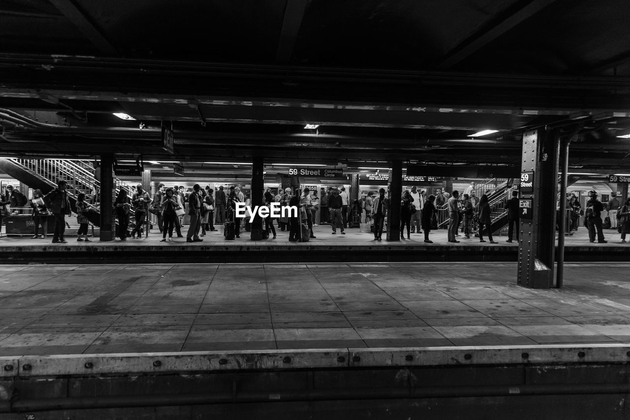 PEOPLE WALKING ON RAILROAD STATION PLATFORM