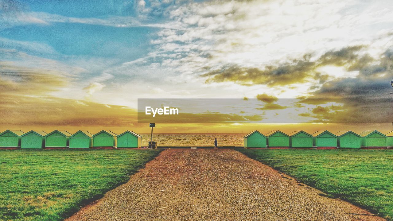 Scenic view of beach against sky during sunset, with a little houses. brighton beach