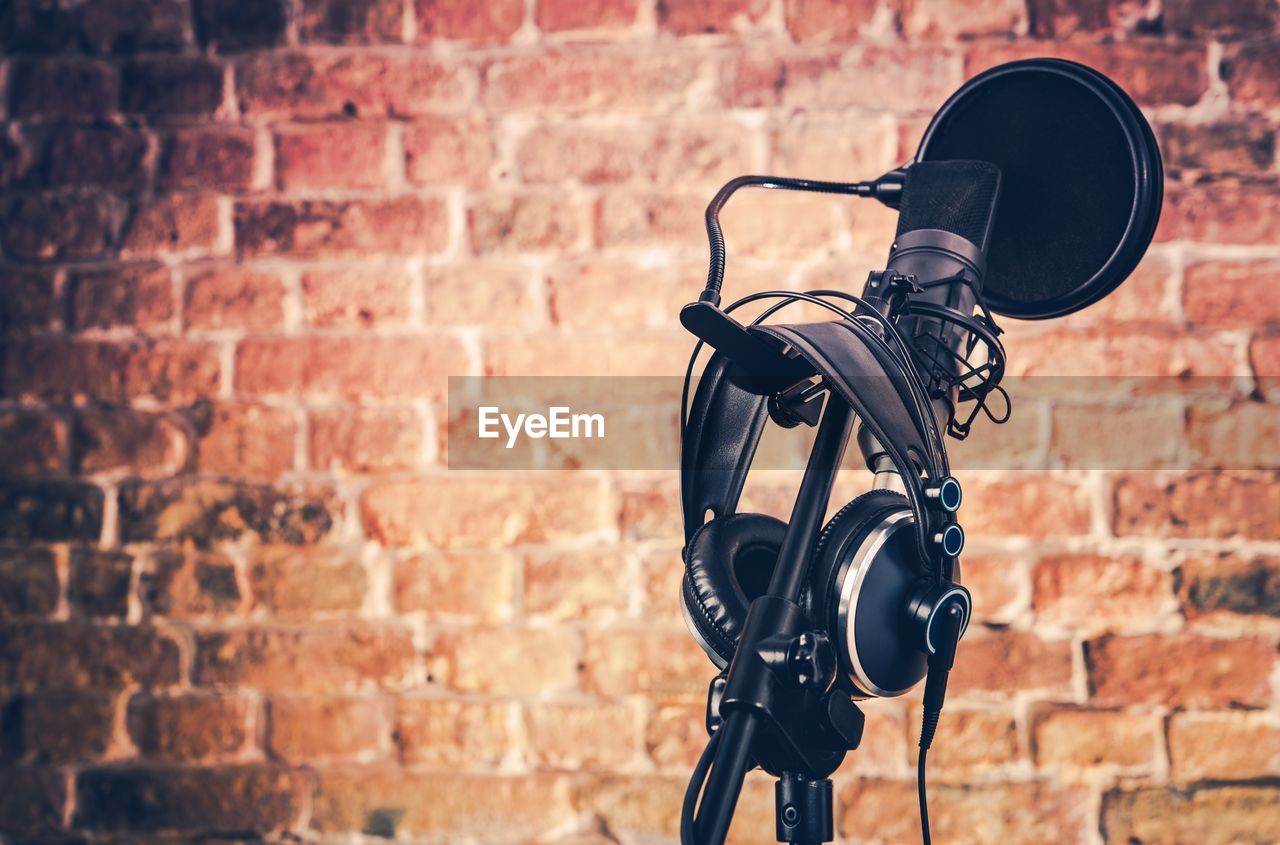 Close-up of microphone against brick wall