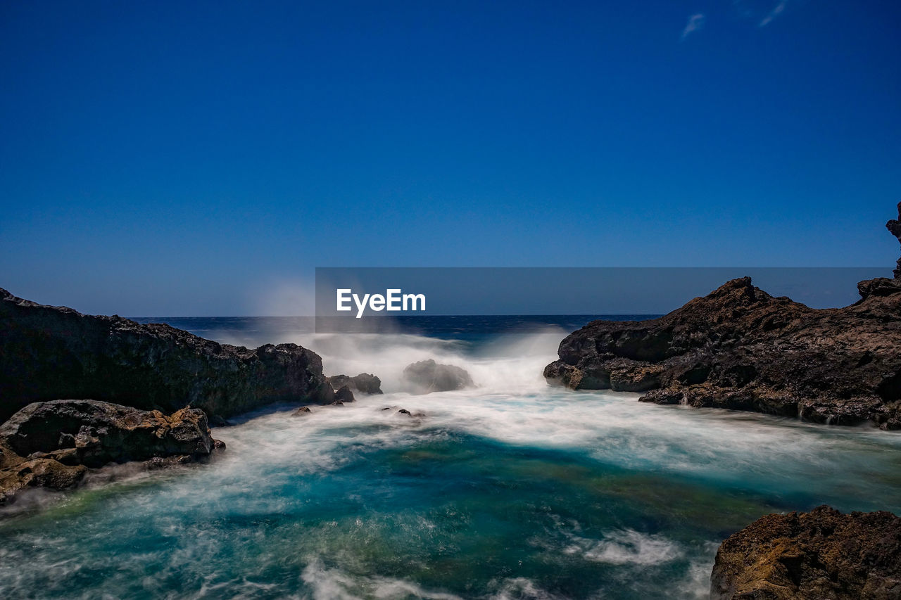 SCENIC VIEW OF SEA AGAINST ROCKS