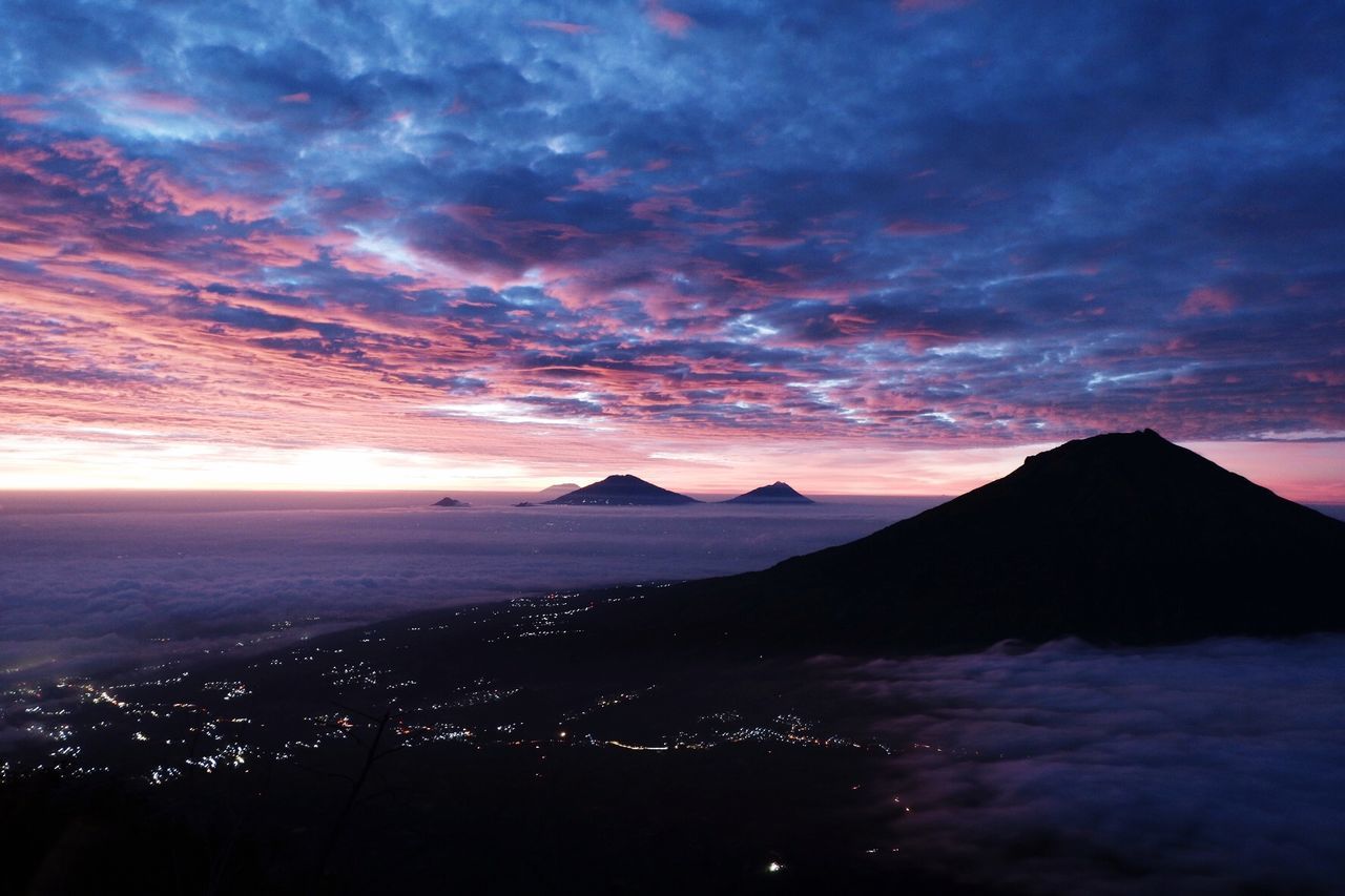 Scenic view of silhouette mountain against dramatic sky during sunset