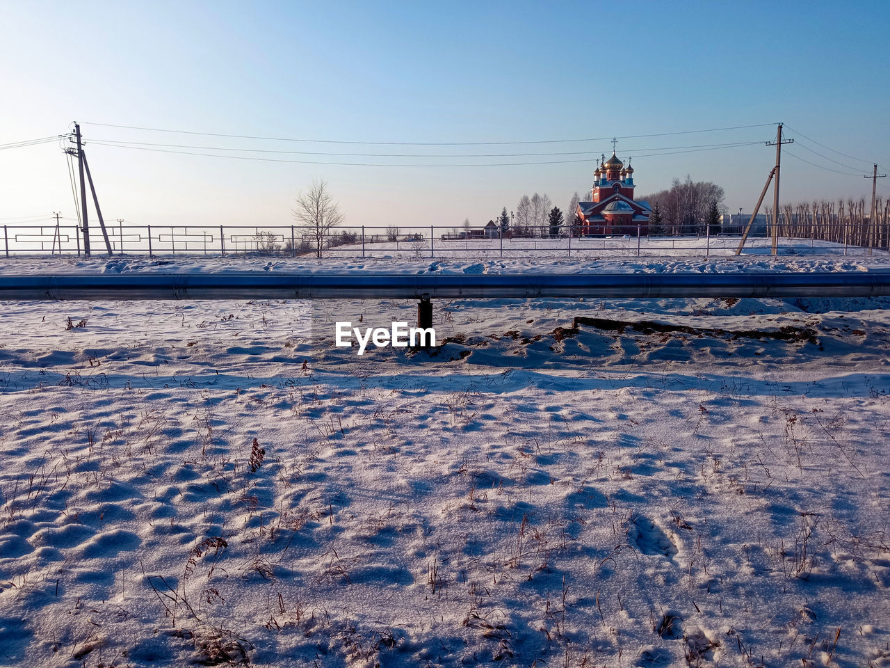 Snow covered field with a church 