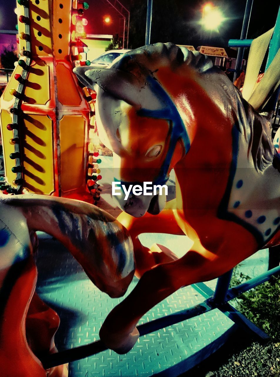 Close-up of horse at carousel in park at night