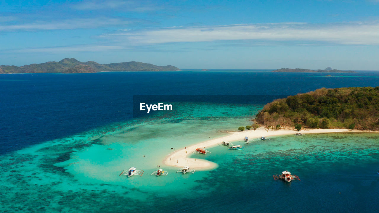Seascape tropical island with sand bar, turquoise water and coral reef. ditaytayan, palawan
