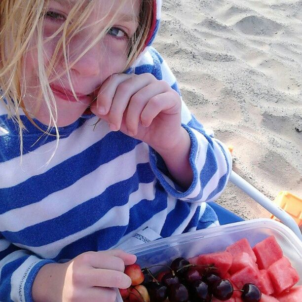 Portrait of girl eating fruit salad at beach