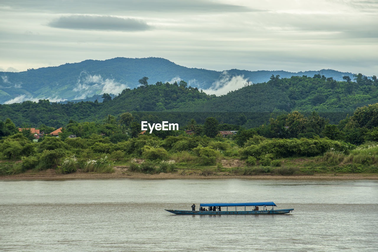 Passenger boat on the mekong river with fog and mountain background