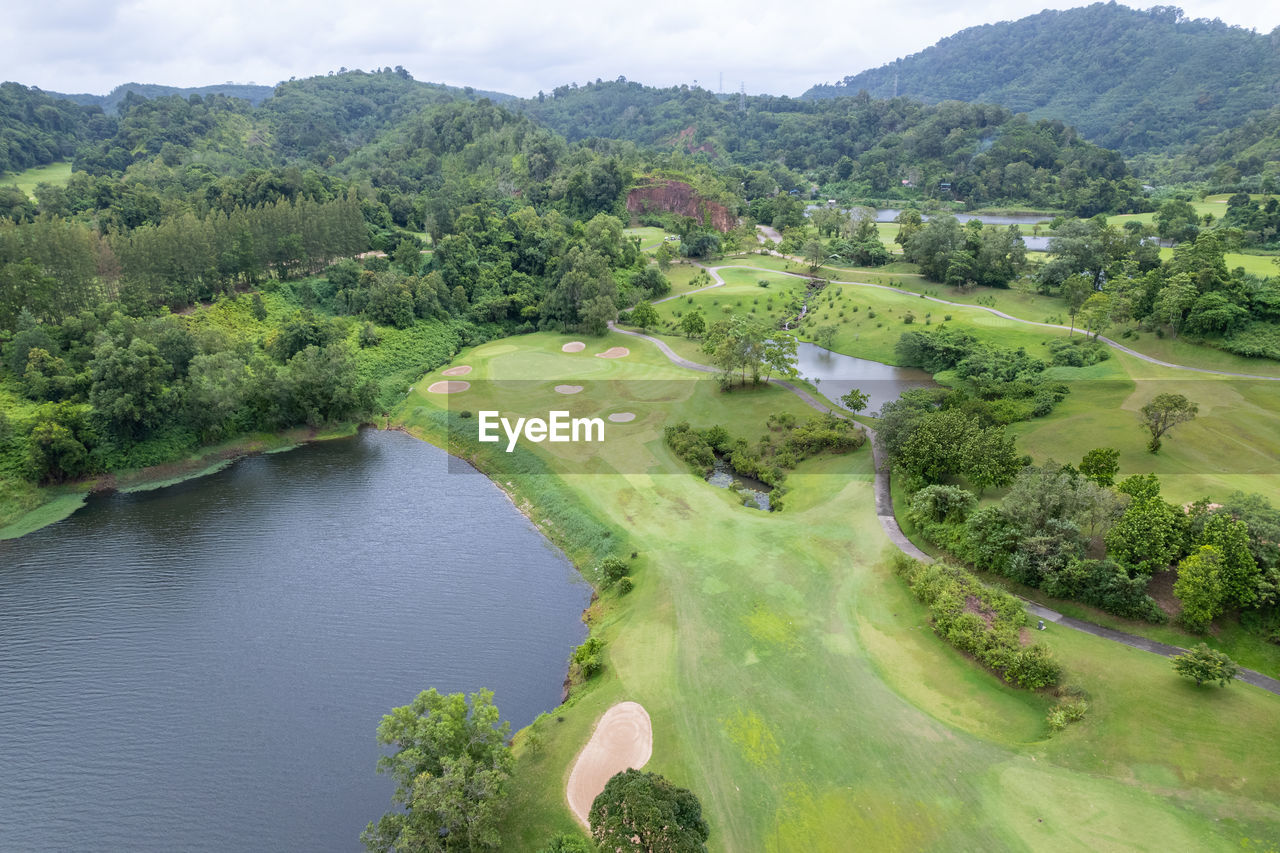 high angle view of river amidst trees against sky