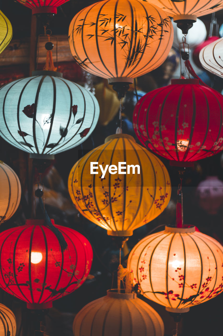 LOW ANGLE VIEW OF ILLUMINATED LANTERNS IN MARKET