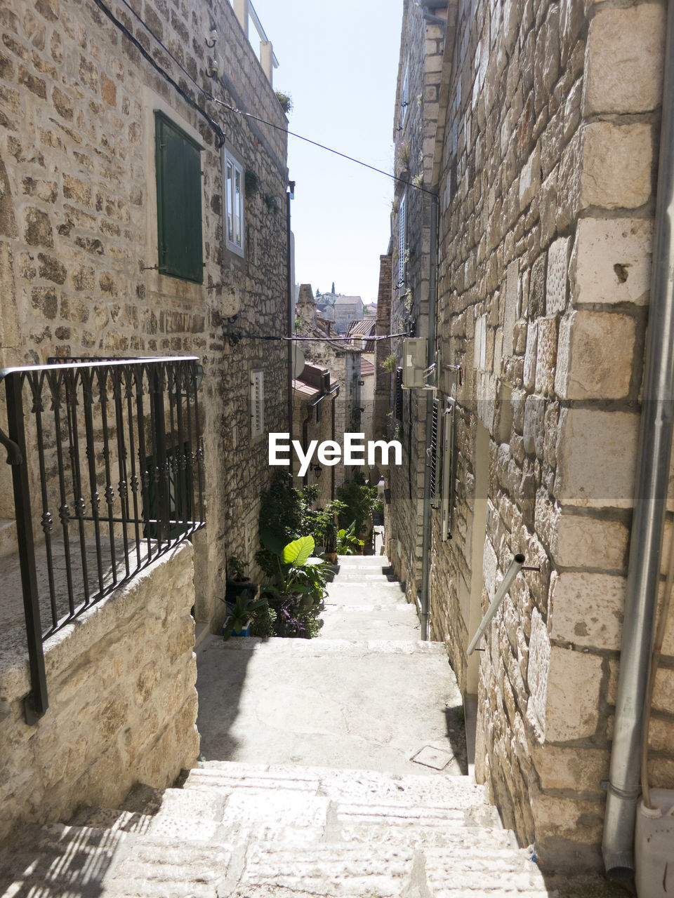 Steps amidst buildings on sunny day