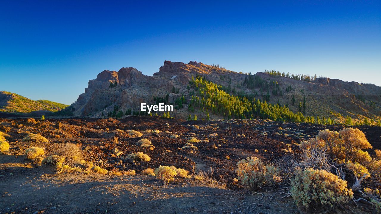 Scenic view of rocky mountains against clear blue sky