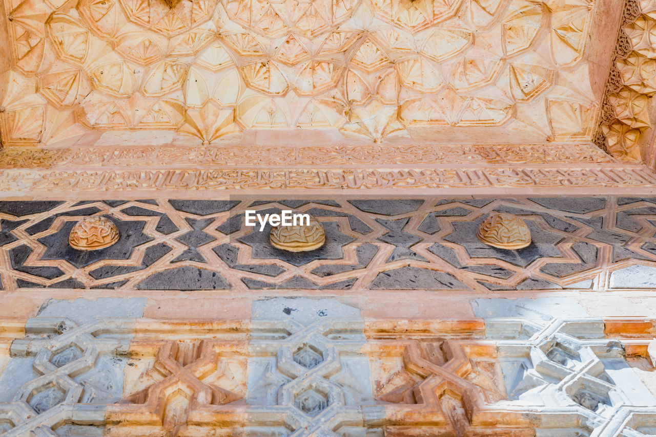 CLOSE-UP OF CARVINGS ON WALL OF BUILDING