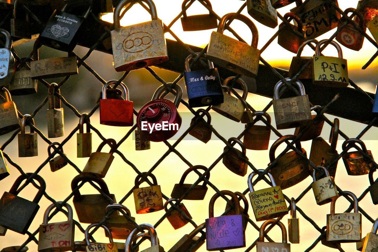 Full frame shot of love padlocks hanging on chainlink fence