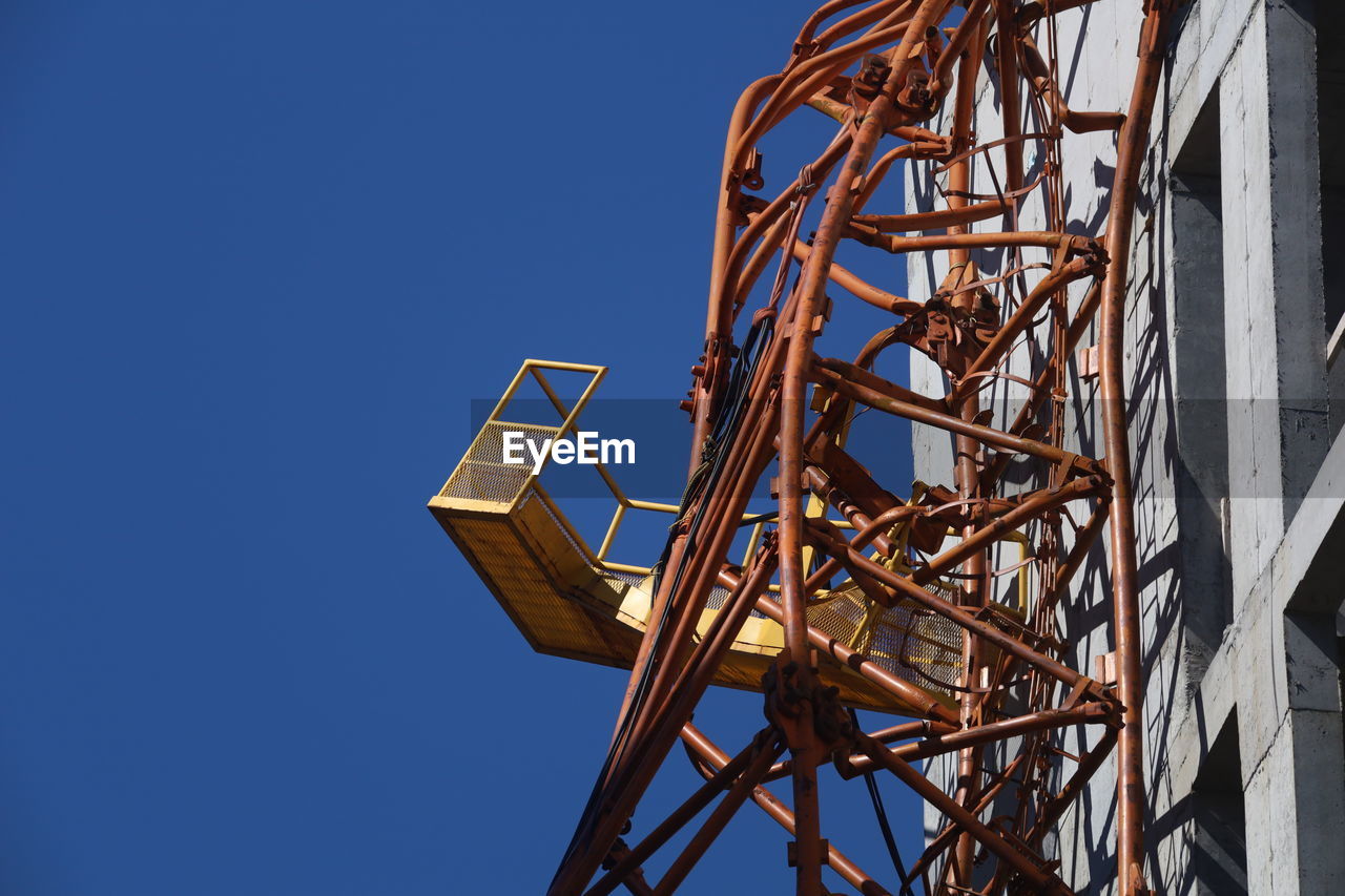 LOW ANGLE VIEW OF CRANE AGAINST SKY