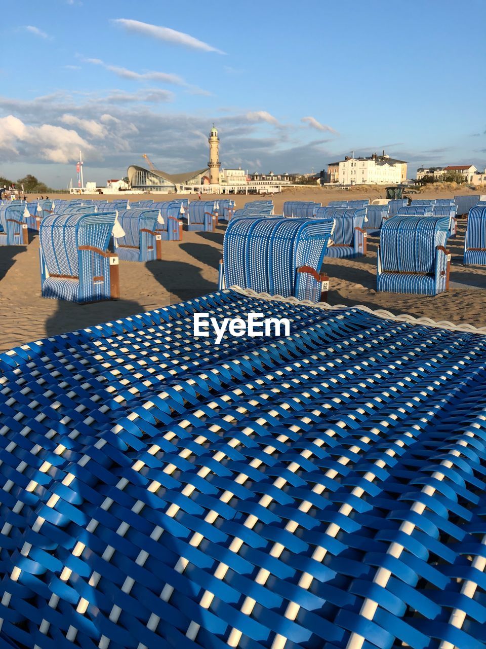 View of beach chair at beach against blue sky