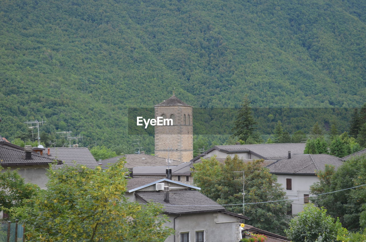 High angle view of houses amidst trees and buildings
