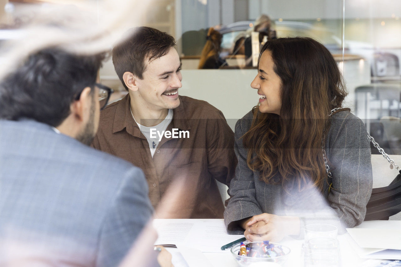 Smiling couple meeting with real estate agent in office