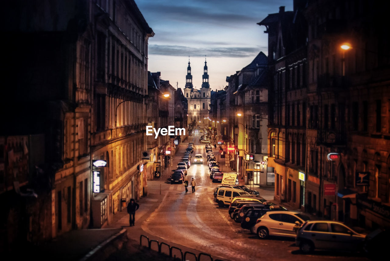 Road amidst buildings in city at night