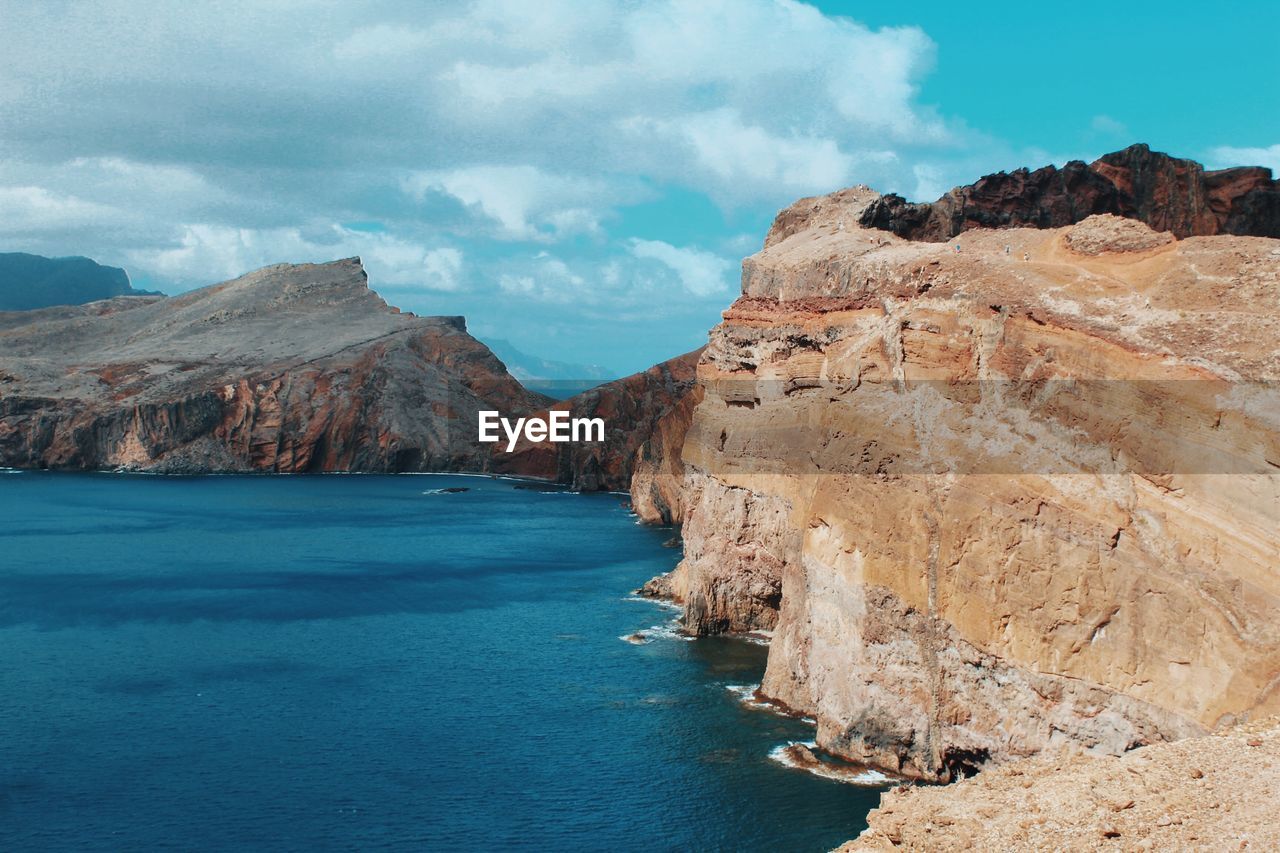 Scenic view of sea and mountains against sky