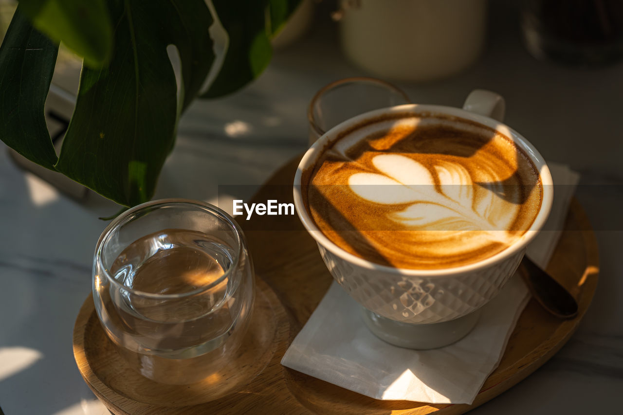 HIGH ANGLE VIEW OF COFFEE ON TABLE IN GLASS