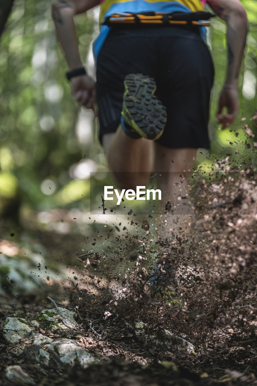 Mud splash by man running on path at forest