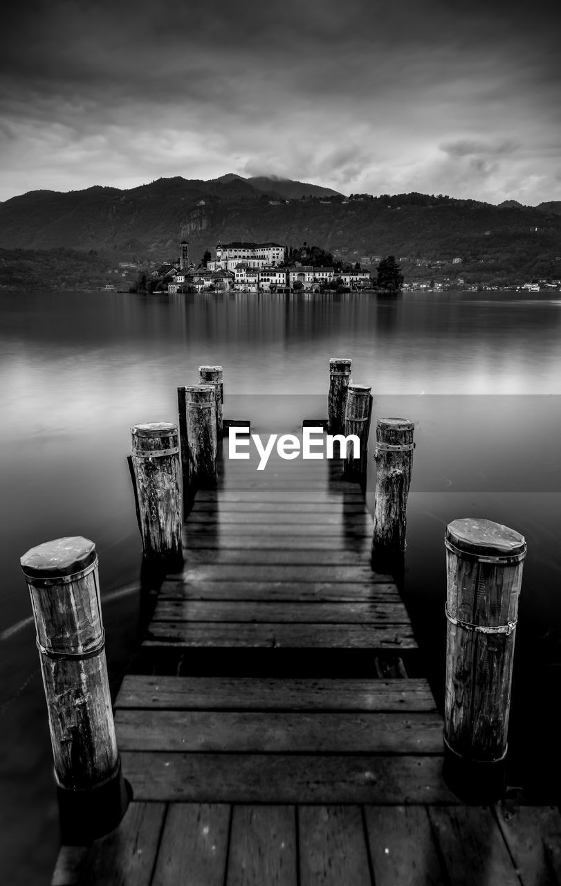 Wooden pier at lake against sky