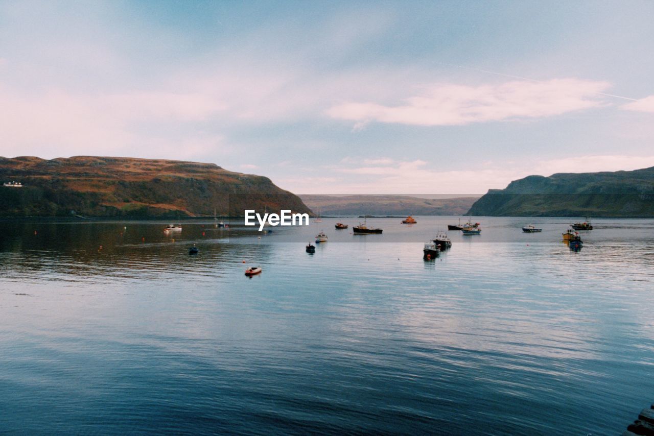 BOATS IN LAKE AGAINST SKY