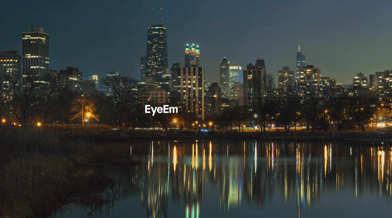 Reflection of illuminated buildings in city at night