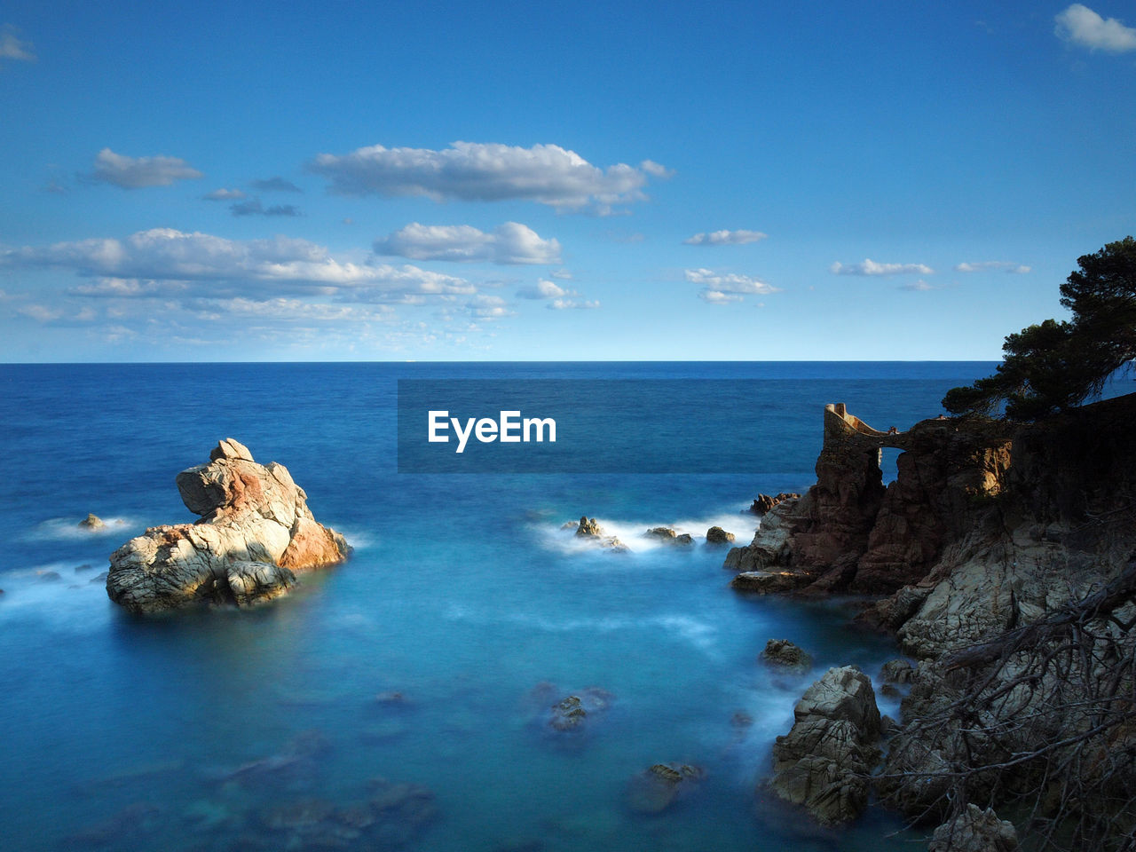 Rock formations in sea against blue sky