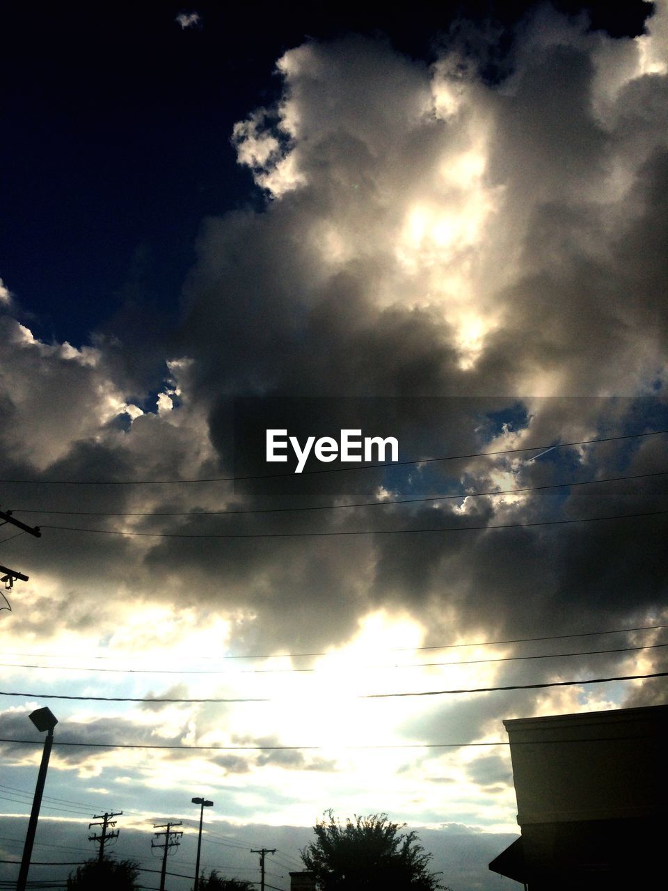 LOW ANGLE VIEW OF STREET LIGHTS AGAINST CLOUDY SKY