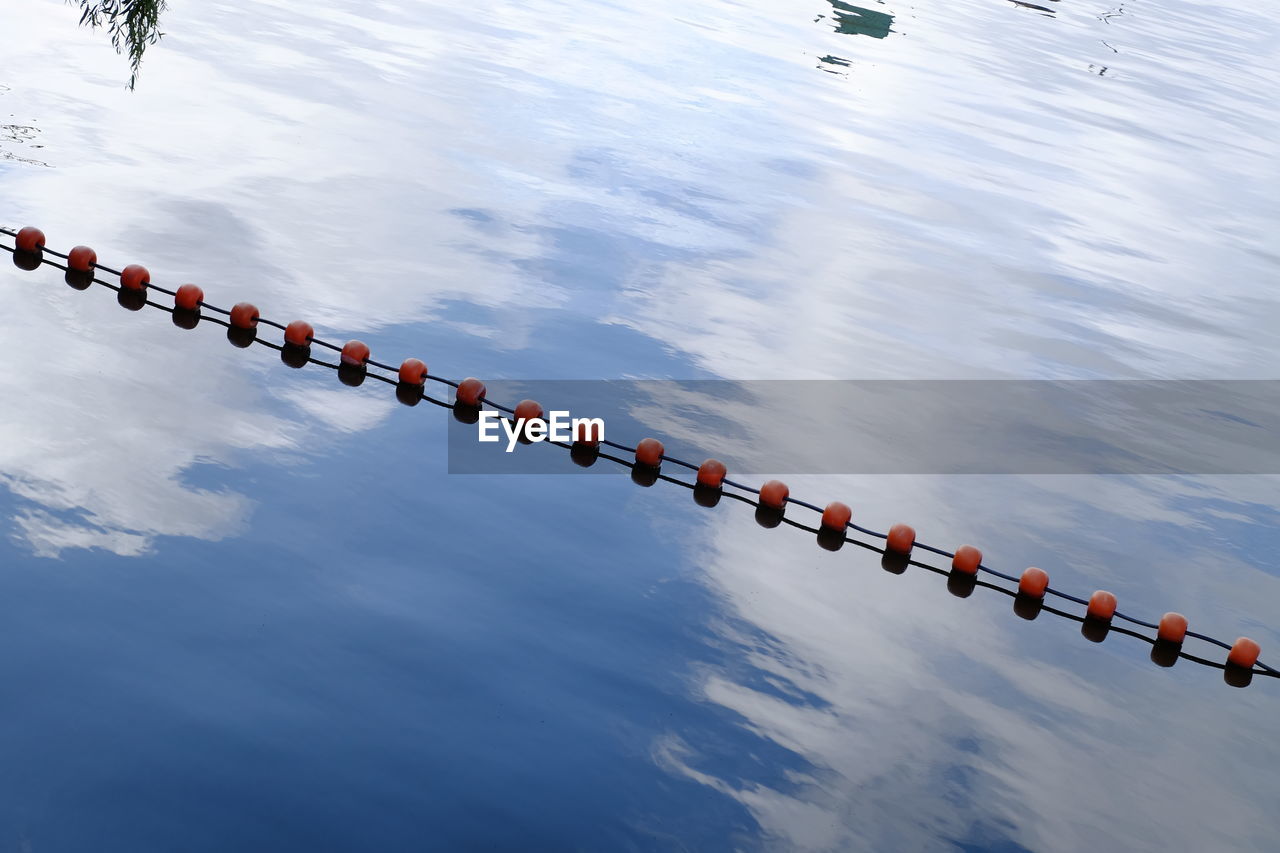 HIGH ANGLE VIEW OF WOODEN POST IN LAKE