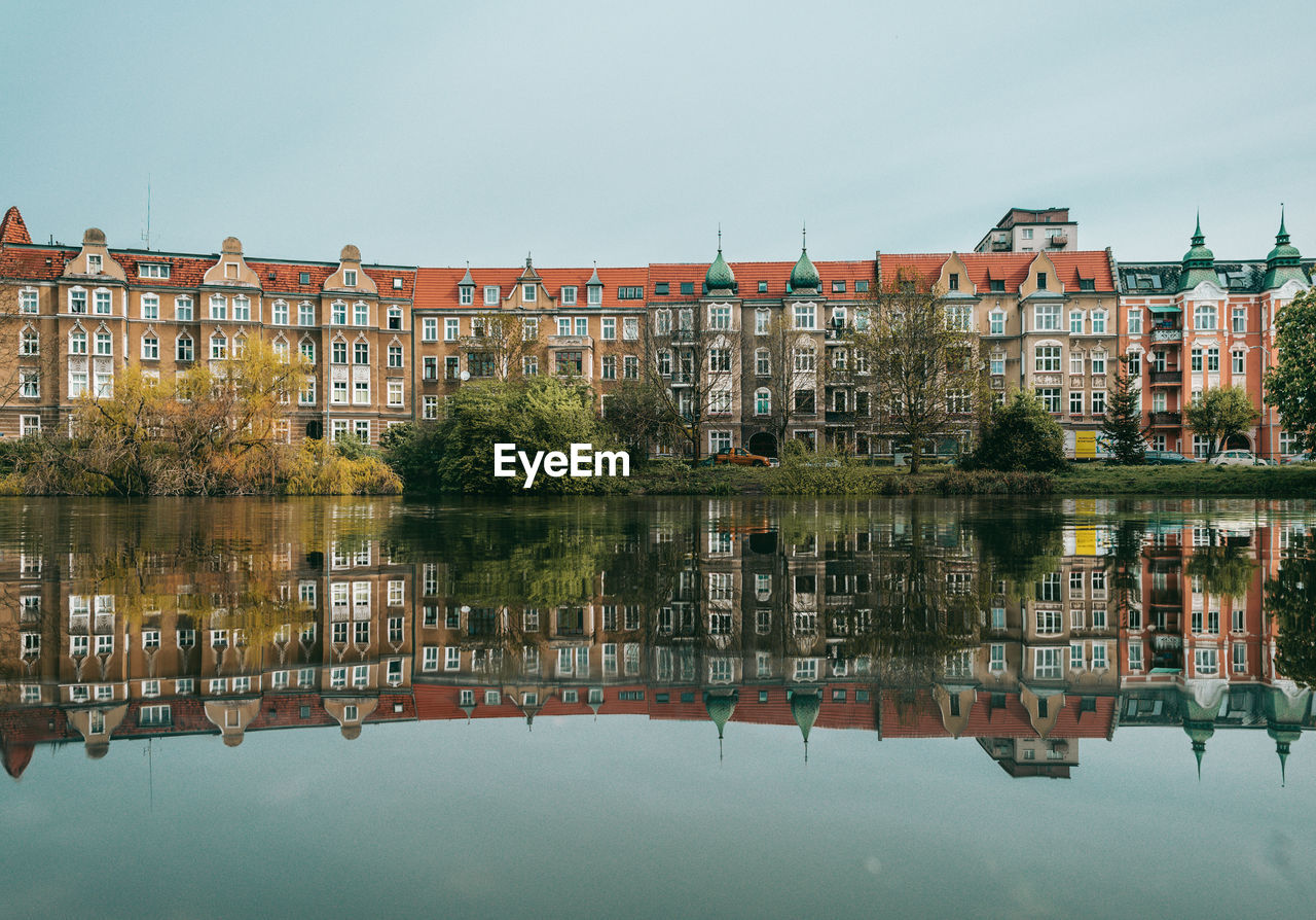 Reflection of building in lake against sky